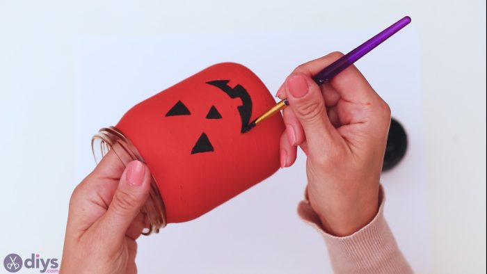 painting old candle jar as a new pumpkin design
